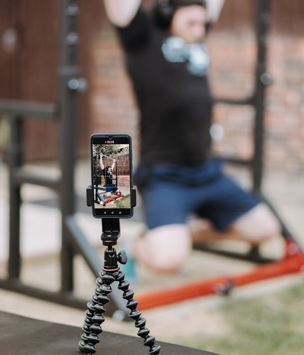 Man performing a controlled strength exercise in a modern gym.